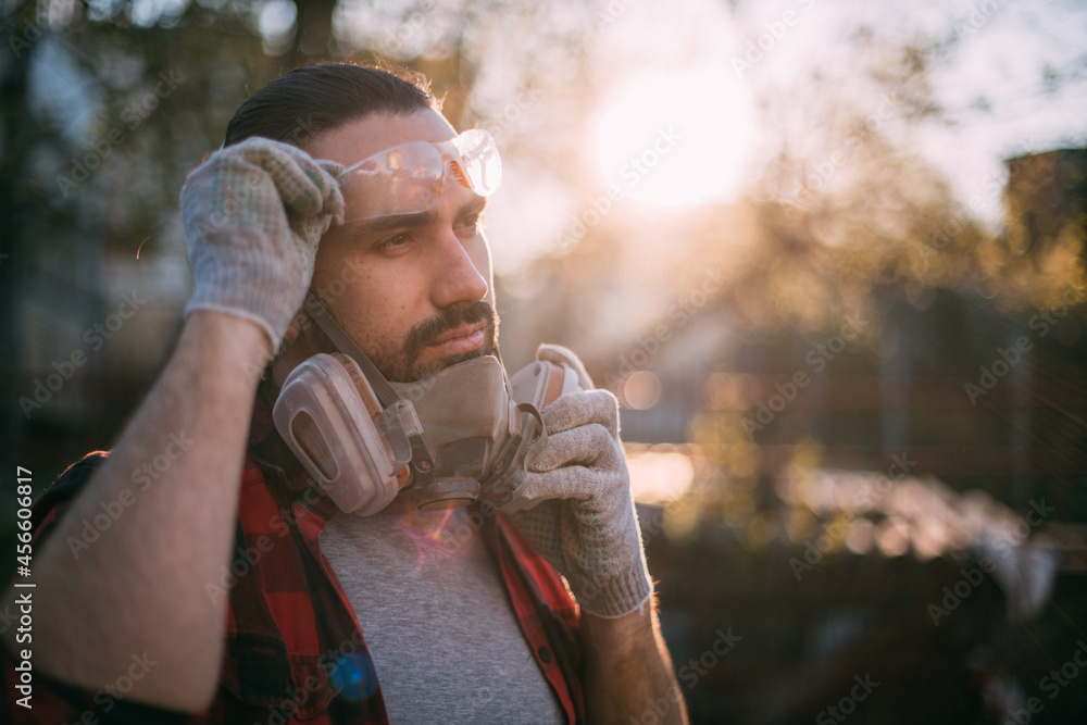 A man in goggles, gloves and a respirator. Means of protection. A man in goggles, gloves and a respirator. Means of protection.