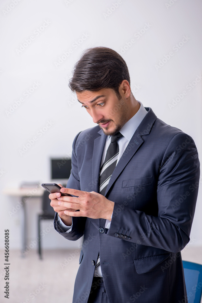 Young male employee sitting at workplace Young male employee sitting at workplace
