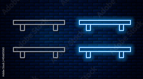 Glowing neon line Empty wooden shelves icon isolated on brick wall background. Vector