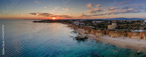 Aerial sunset over Portimao Praia do Vau beach, famous tourist destination in  Algarve, Portugal.