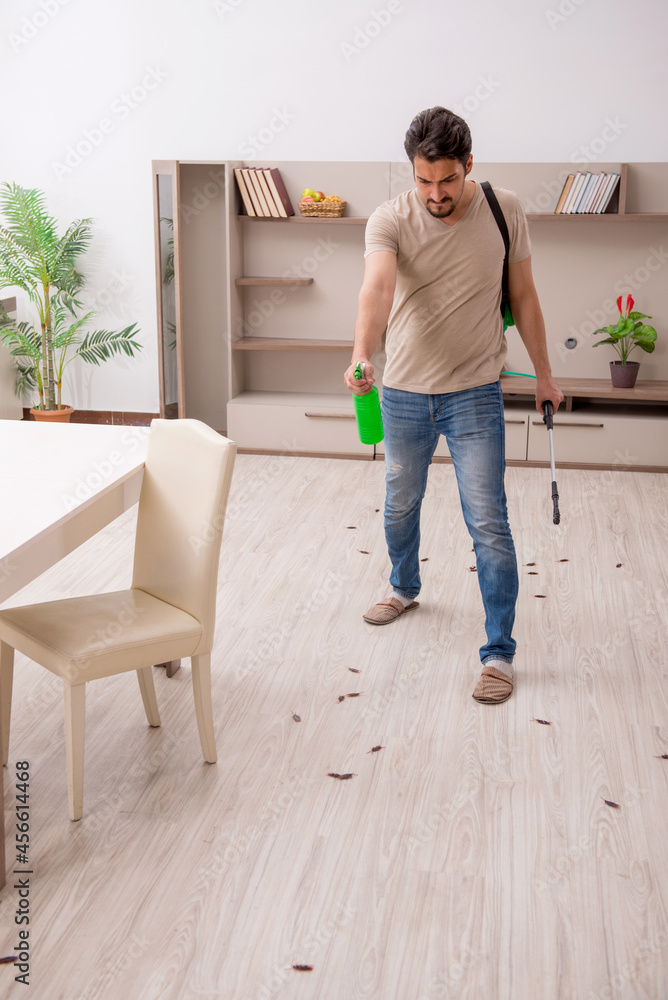Young man exterminating cockroaches at home Young man exterminating cockroaches at home