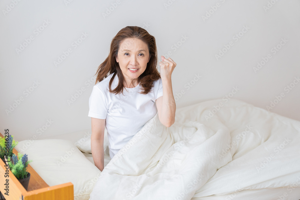 シニア女性 ベッド 笑顔 シニア女性 ベッド 笑顔
