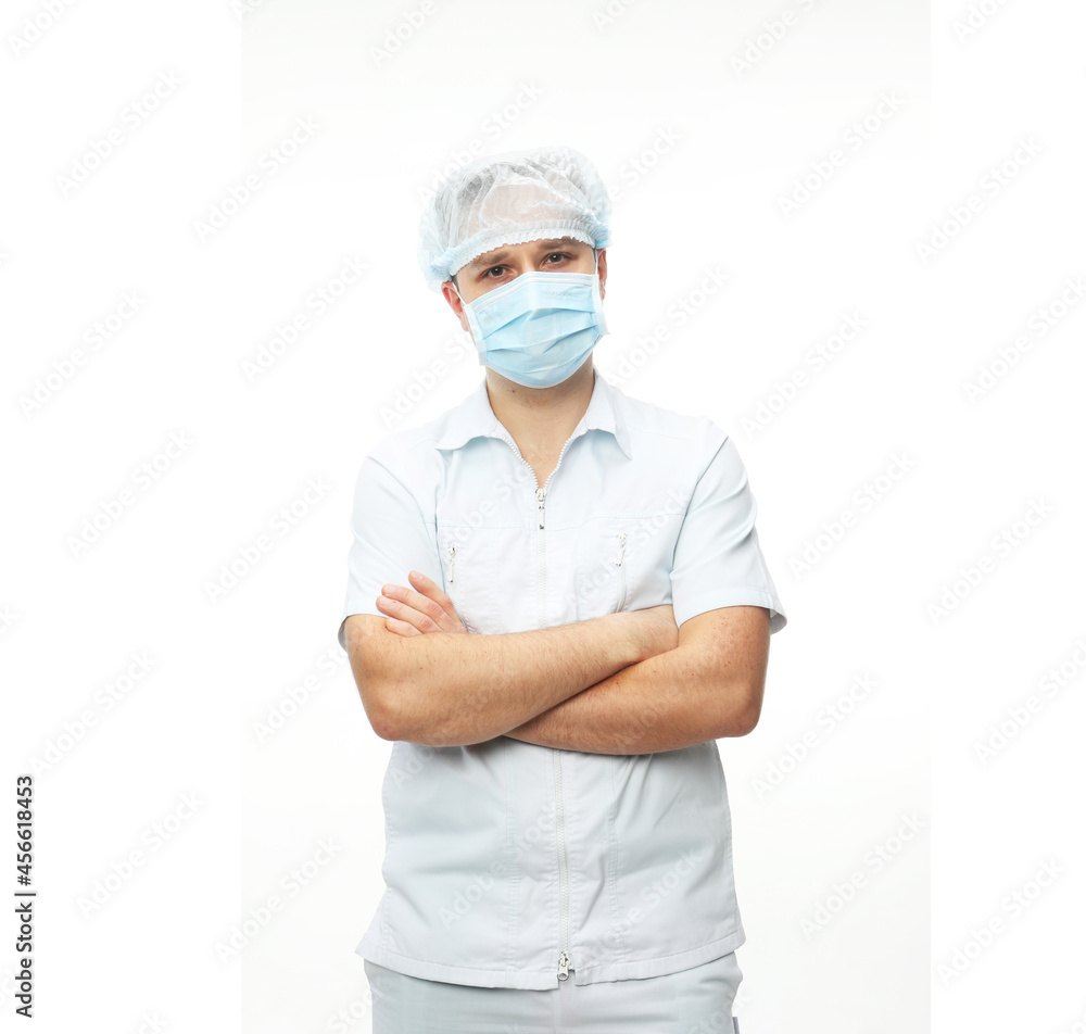 Young male doctor wearing mask stands with his arms crossed Young male doctor wearing mask stands with his arms crossed