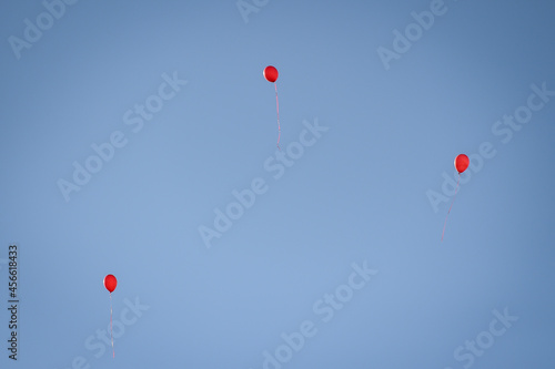 Red balloons, symbol of World Duchenne Awareness Day, are released into the blue open sky. photo