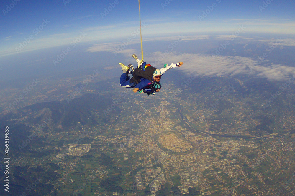 Fototapeta premium jump with an instructor in tandem in clear good weather , from below you can see the outlines of the historic center of Lucca , in summer