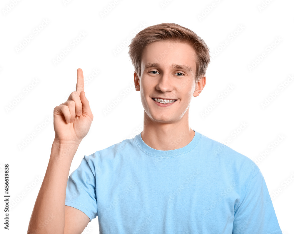 Handsome man with dental braces showing something on white background Handsome man with dental braces showing something on white background