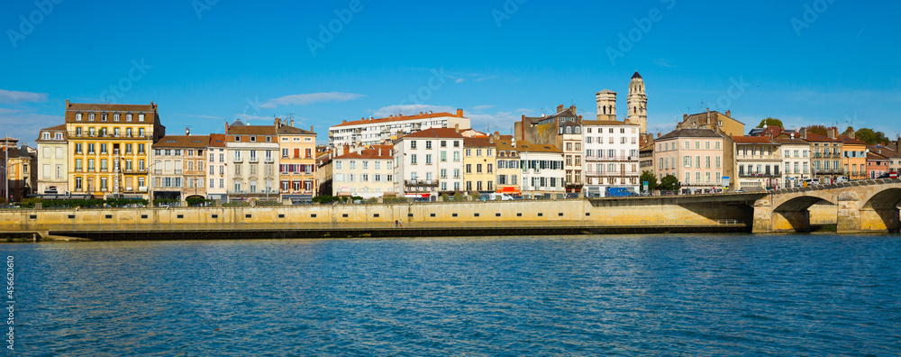 View of Macon cityscape across Saone river on blue autumn sky as background, France..