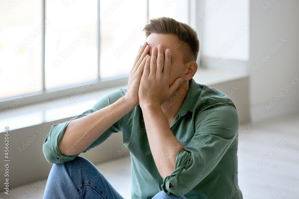 Depressed young man in empty room Depressed young man in empty room