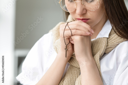Praying young woman in office