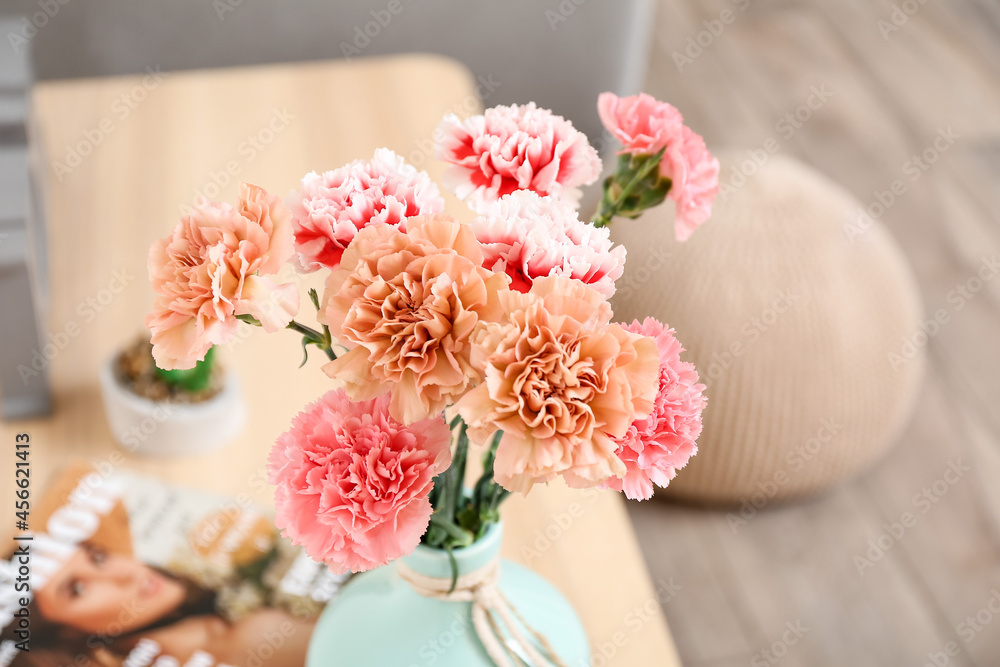 Vase with beautiful carnations on table in room Vase with beautiful carnations on table in room