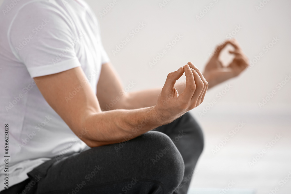 Young man practicing yoga at home, closeup