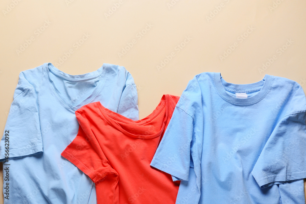 Stylish t-shirts on color background, closeup Stylish t-shirts on color background, closeup