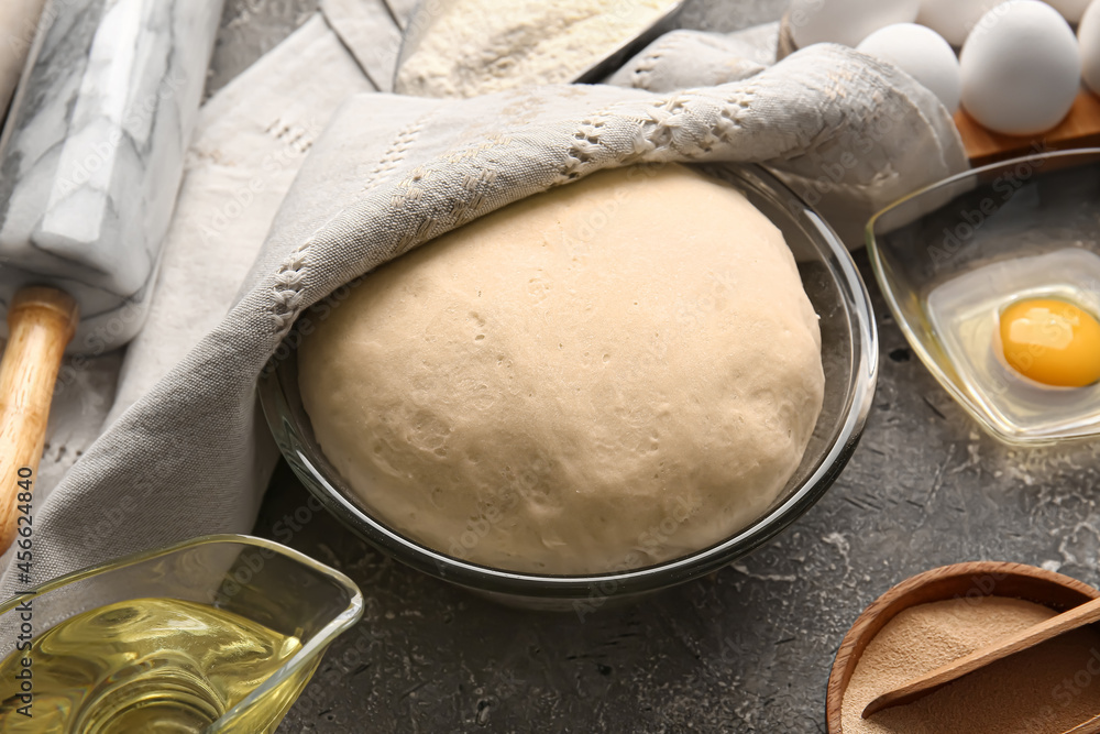 Composition with fresh dough and ingredients on grunge background Composition with fresh dough and ingredients on grunge background