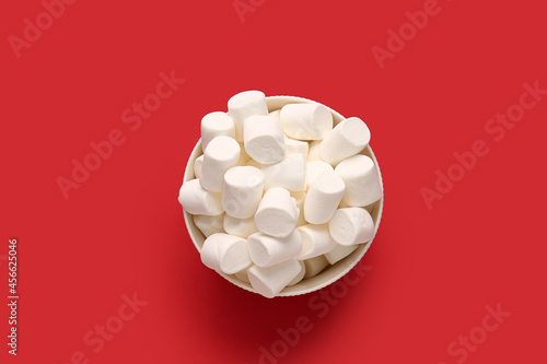 Bowl with tasty marshmallows on color background