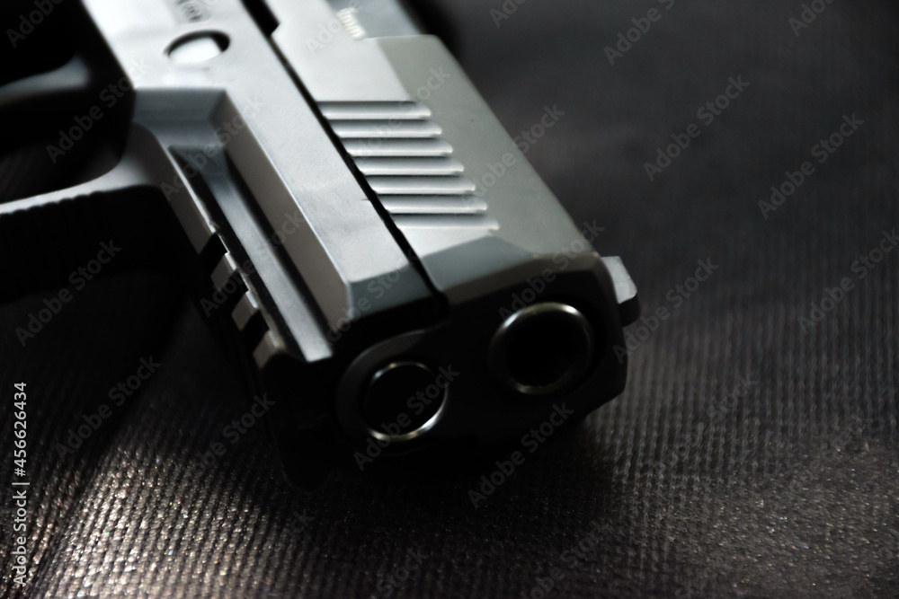 Automatic black 9mm pistol on black leather table. Soft and selective focus specific on gun. Automatic black 9mm pistol on black leather table. Soft and selective focus specific on gun.