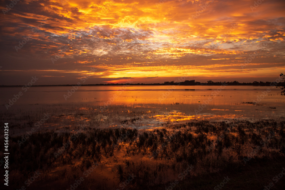 Scenic view dramatic beautiful sunset sky. Natural Sunset Sunrise on meadow silhouette shadow dark land. Vibrant dramatic sky on sunset, dawn, sunrise in Countryside. Landscape Colorful Sky At Sunset