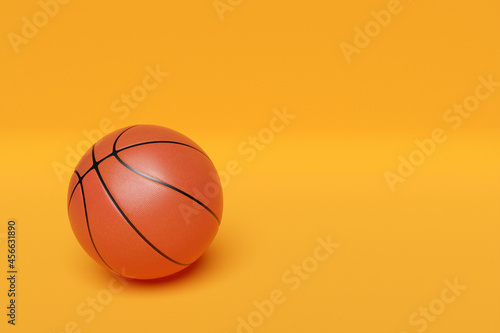 3d illustration of classic orange basketball ball with stripes on yellow isolated background