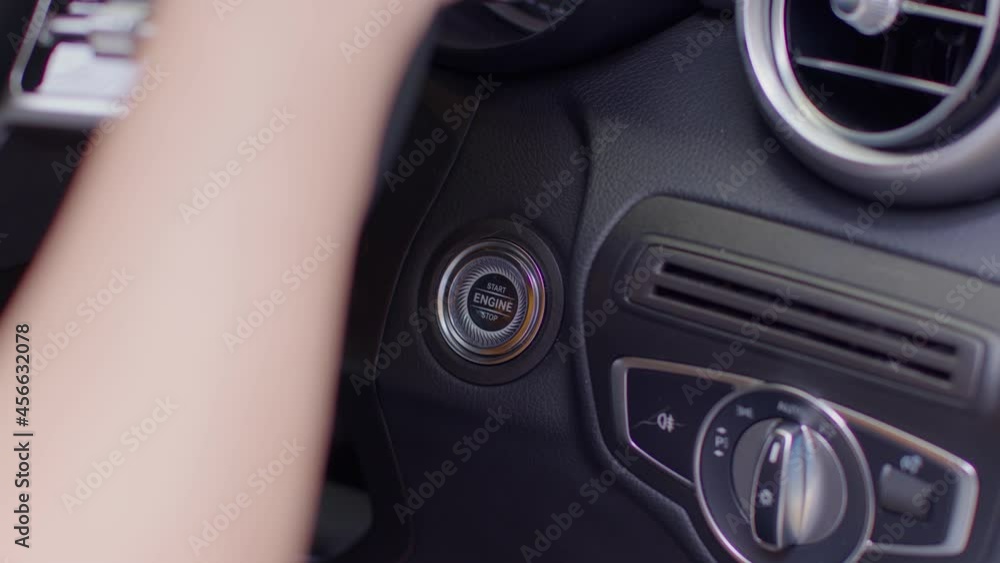 Close up finger push the engine button to start or stop on car.Driver start engine by pushing automatic button system.Keyless System Concept Close up finger push the engine button to start or stop on car.Driver start engine by pushing automatic button system.Keyless System Concept