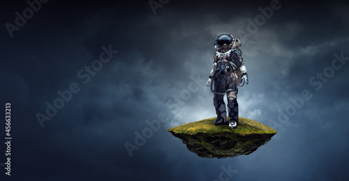 Astronaut walking on an unexplored planet . Mixed media photo