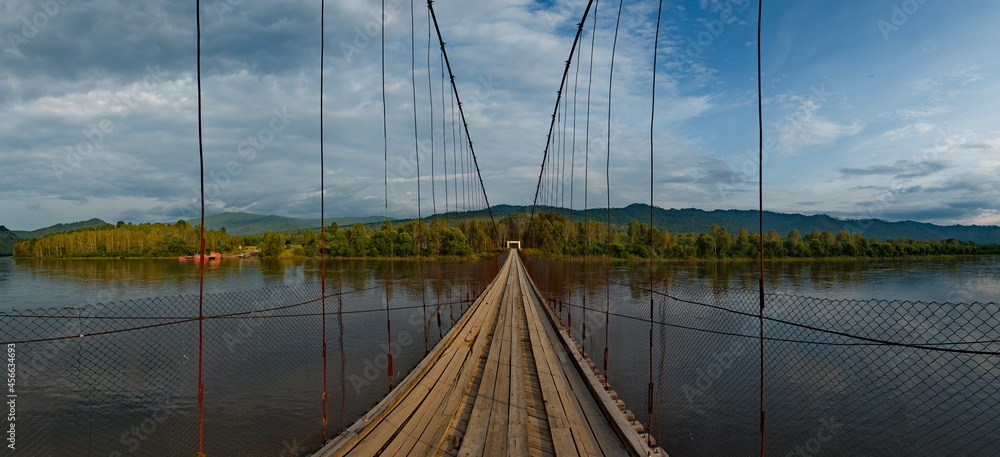 Naklejka premium Russia. Chita region. A suspension road bridge over the Chikoy River, connecting the district center with the village of Krasny Priisk.