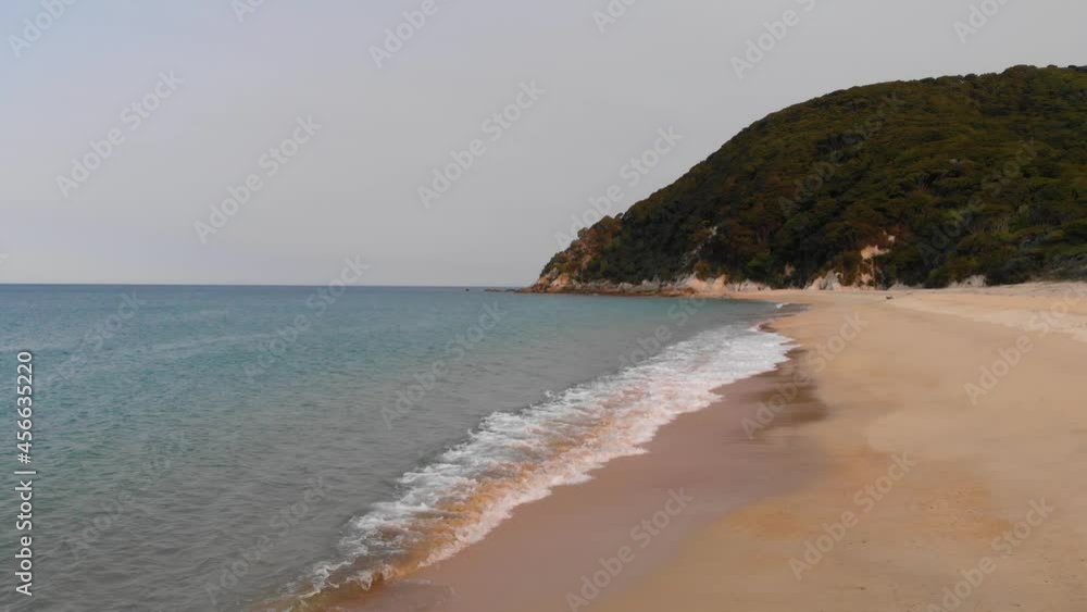 Flying low above calm sea with gentle waves on late summer afternoon on the remote coast of New Zealand in 4K, romantic empty beach. Flying low above calm sea with gentle waves on late summer afternoon on the remote coast of New Zealand in 4K, romantic empty beach.