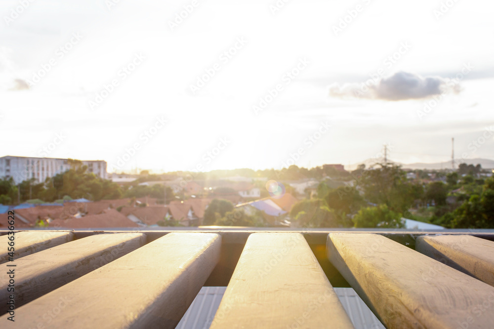 Fototapeta premium Rooftop view of sunset overbuilding city and orange skyline in Thailand, cityscape with sun light at dusk from the terrace apartment, Fire escape ladder