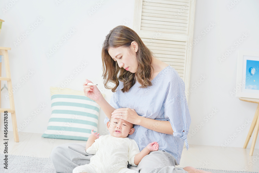 赤ちゃんの体温を測る母親 赤ちゃんの体温を測る母親