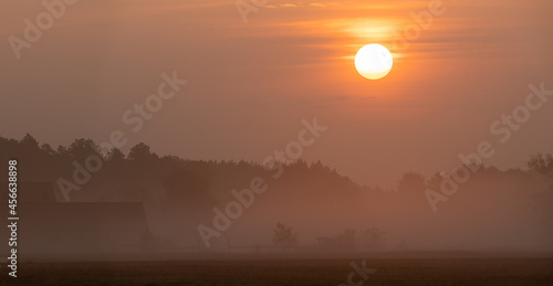 Misty sunrise over an agricultural farm