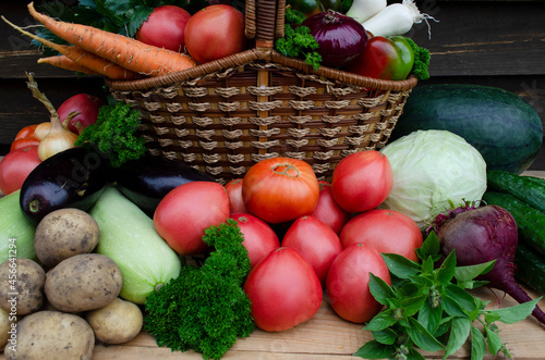 basket of fresh vegetables on wooden background