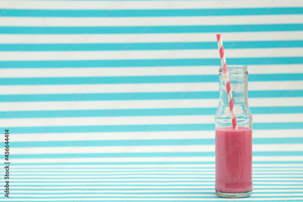 strawberry milk in traditional glass bottles with on stripes background strawberry milk in traditional glass bottles with on stripes background