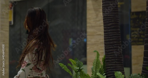 Sexy young woman sits at the mall before turning and her hair flowing in the wind photo