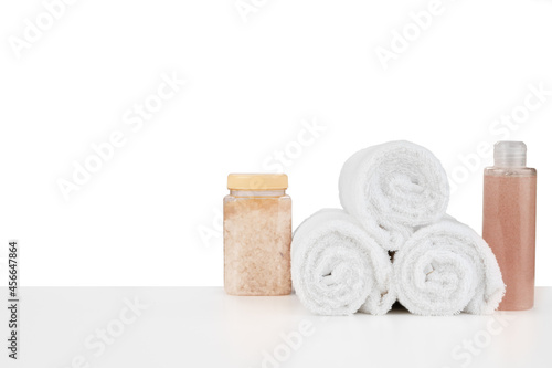 Composition of cosmetic bottles and towels isolated on white