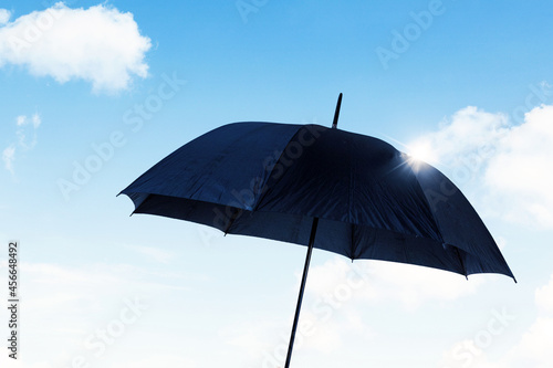 Black umbrella with blue sky background