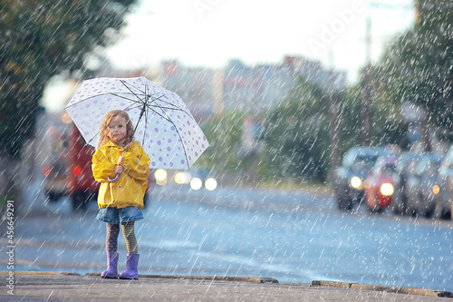 Fotografie little girl with an umbrella / small child, rainy autumn walk, wet weather child
