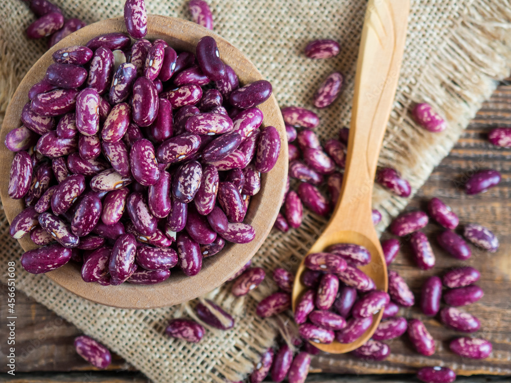 red beans with a pattern. (Delicious variegated, raw common beans) in a wooden bowl on an old wooden table, legumes. Copy space red beans with a pattern. (Delicious variegated, raw common beans) in a wooden bowl on an old wooden table, legumes. Copy space
