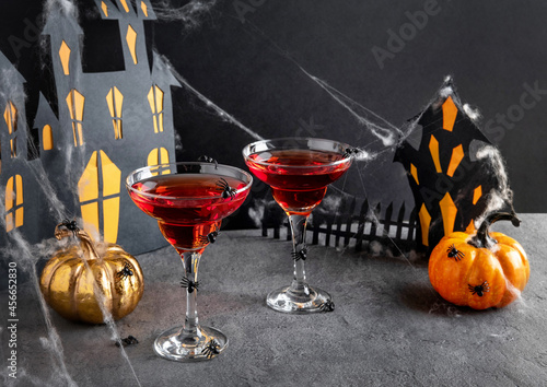 Two red Halloween cocktails with party decorations on dark background. Happy Halloween concept.