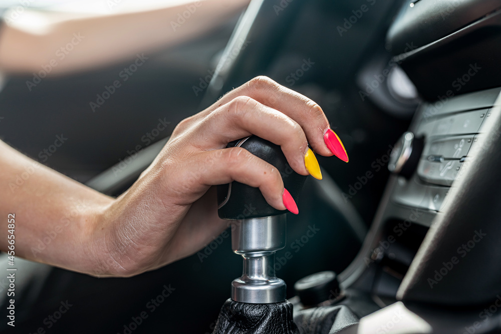 female driver hand shifting gear shift knob manually before the beginning of ride