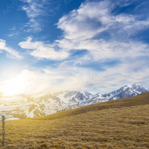 hiker group walking over mountain pass at the sunset, natural mountain travel background © Yuriy Kulik