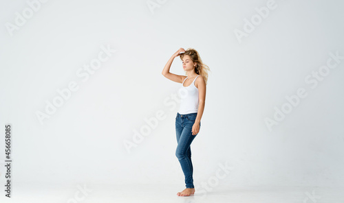 woman in jeans barefoot stands on the floor fashion emotions motion