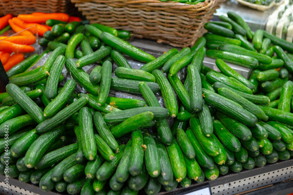 Pile of fresh cucumbers on counter in supermarket Pile of fresh cucumbers on counter in supermarket