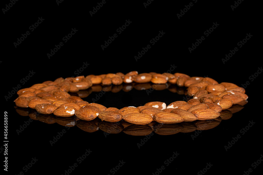 Lot of whole almond placed in circle on black glass Lot of whole almond placed in circle on black glass