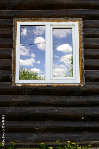 The sky in the window against the background of a log house