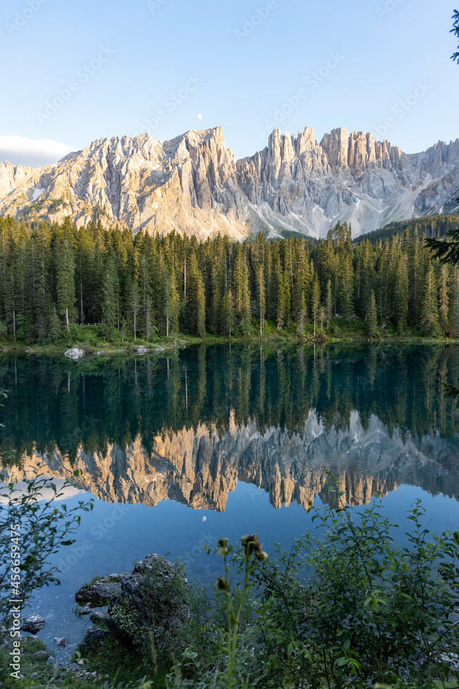Splendid view of Lake Carezza in South Tyrol. The mountains and the forest are perfectly reflected on the lake, a suggestive image. A dream place for a relaxing holiday in nature.