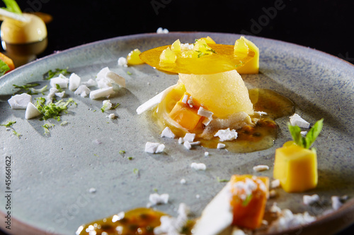 luxury hand made Micheline Summer in the Park Mango Passion dessert on white black background photo