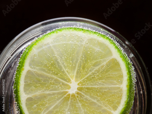a glass of fresh drinking water and lime. mineral water as a means to quench thirst. on a black background.