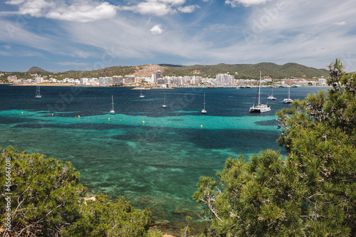 Bay of Ibiza coastline with turquoise water and yachts on sunny summer day. View to the Port de Sant Antoni de Portmany