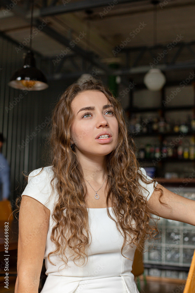 White european girl in white clothes in the restaurant