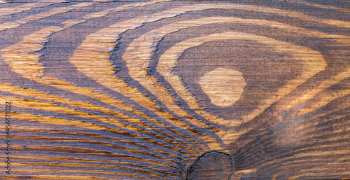 Fragment of wooden plank with knag covered with mordant photo