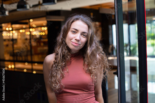 European young girl with dark and curly hair with lights behind