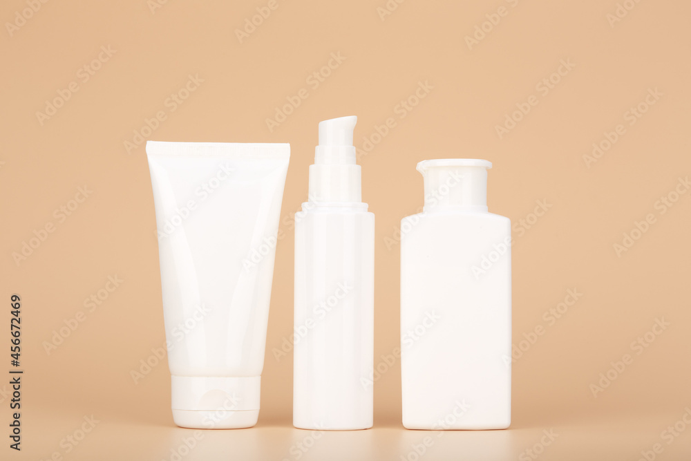 Set of white unbranded cosmetic tubes for face and body care in a row against pastel beige background. Concept of organic, natural, eco friendly cosmetics and beauty products for daily skin care Set of white unbranded cosmetic tubes for face and body care in a row against pastel beige background. Concept of organic, natural, eco friendly cosmetics and beauty products for daily skin care